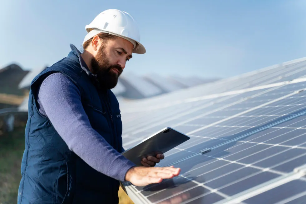 Pracovník Andrew Solar Energy při práci na fotovoltaické elektrárně